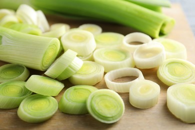 Photo of Fresh chopped leeks on wooden table, closeup