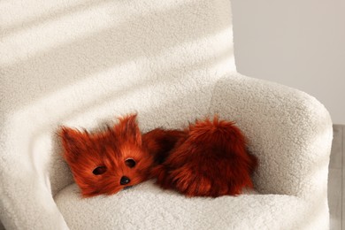 Photo of Quadrobics. Fox mask, gloves and tail on armchair indoors