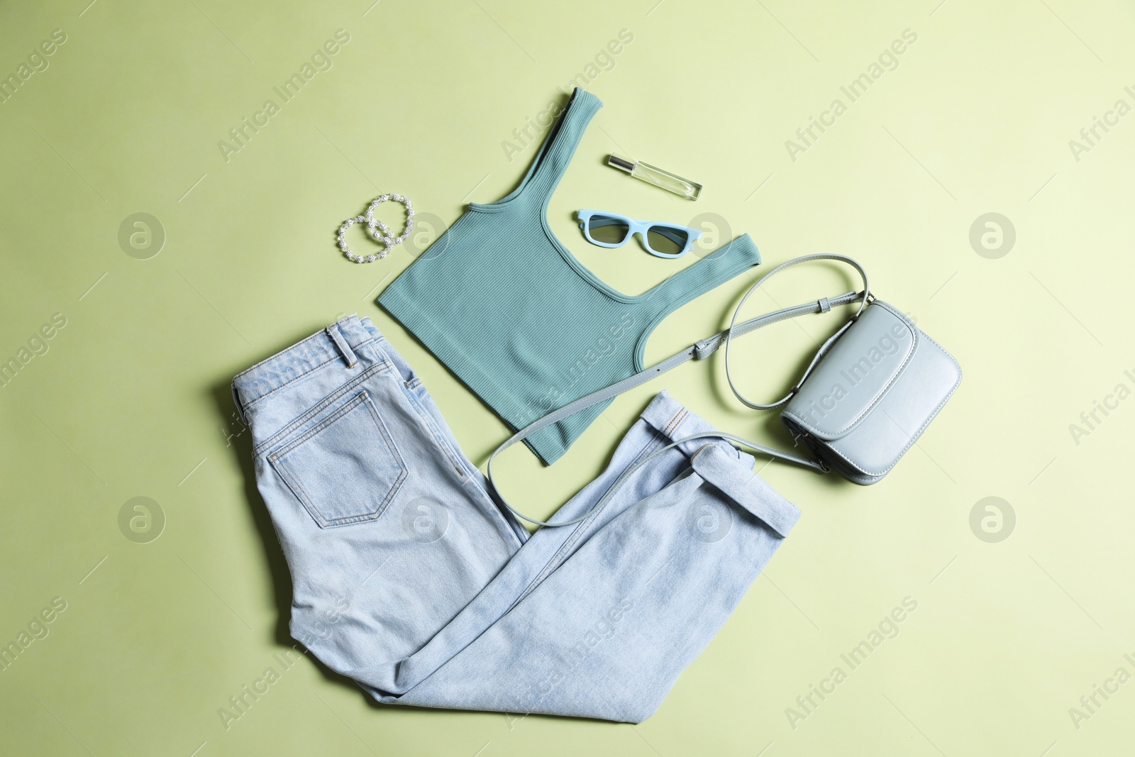 Stylish women's clothes and different accessories on light olive background, flat lay Photo of Stylish women's clothes and different accessories on light olive background, flat lay