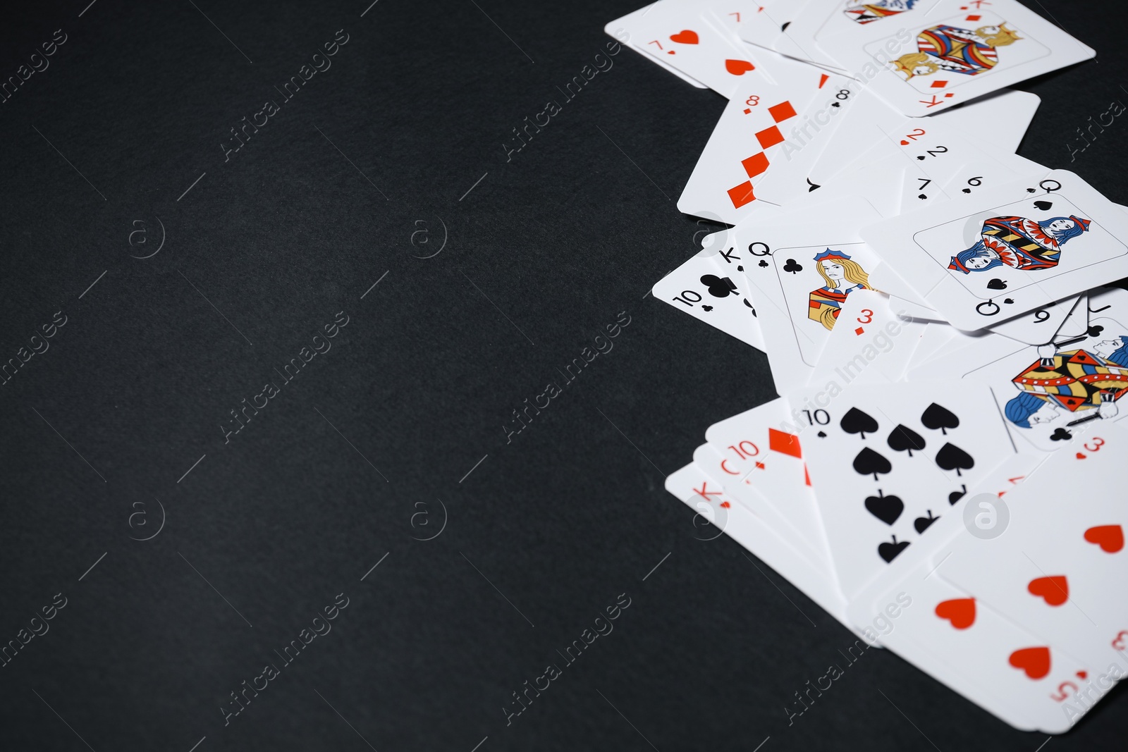 Photo of Playing cards on black background, closeup. Space for text