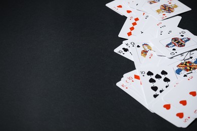 Playing cards on black background, closeup. Space for text