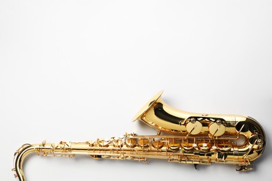 Photo of Jazz. One saxophone on light grey background, top view. Space for text