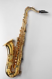 Photo of Jazz. One saxophone on light grey background, top view