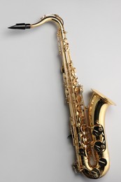 Jazz. One saxophone on light grey background, top view