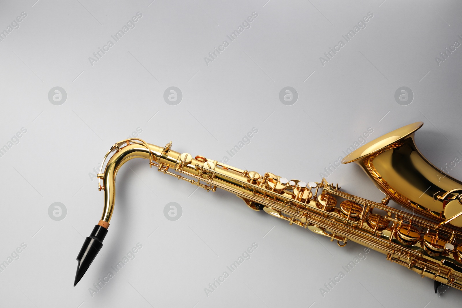 Photo of Jazz. One saxophone on light grey background, top view. Space for text