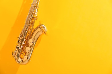 Golden saxophone on yellow background. Space for text