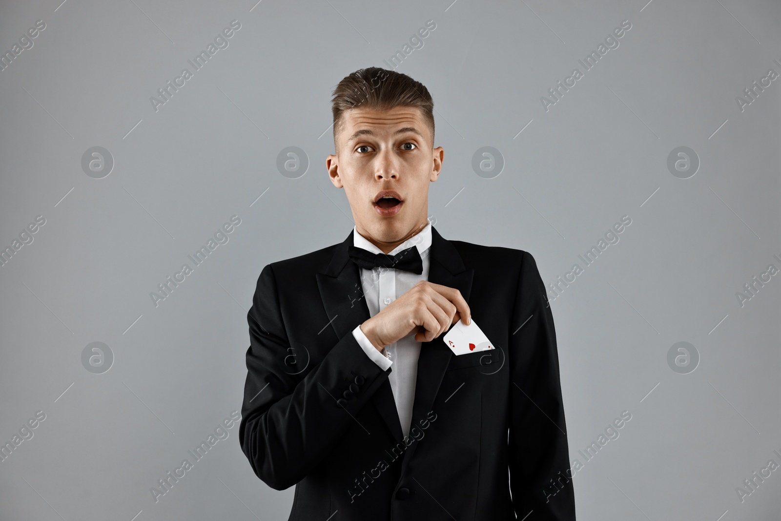 Photo of Illusionist showing playing card on white background, closeup