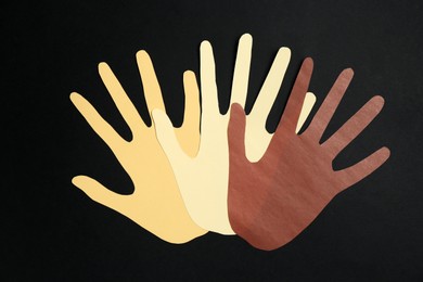 Photo of Stop racism. Hands paper figures of different colors on black background, top view