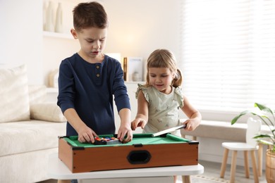 Cute brother and sister playing billiards at home