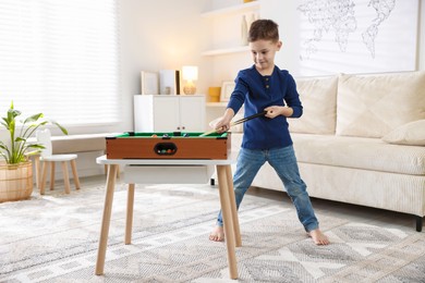 Cute little boy playing billiards at home