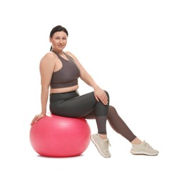 Photo of Plus size woman in gym clothes with fitness ball on white background