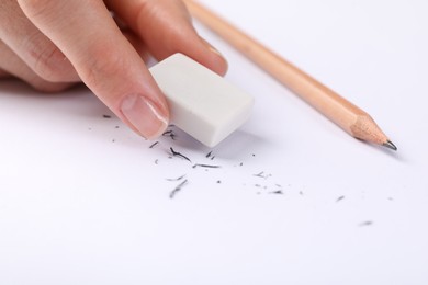 Photo of Woman rubbing eraser against paper, closeup view