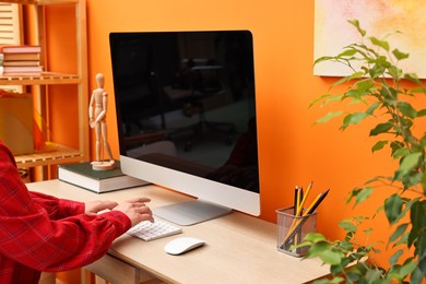 Photo of Woman working on computer at desk indoors, closeup