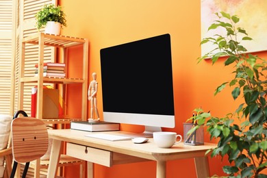 Photo of Comfortable workplace with modern computer and stationery on wooden table indoors