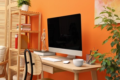 Photo of Comfortable workplace with modern computer and stationery on wooden table indoors