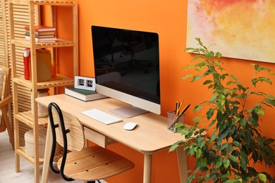 Photo of Comfortable workplace with modern computer on wooden table indoors