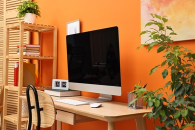 Photo of Comfortable workplace with modern computer on wooden table indoors