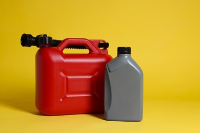 Two colorful plastic canisters on yellow background