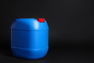 Photo of One plastic canister on black background, space for text