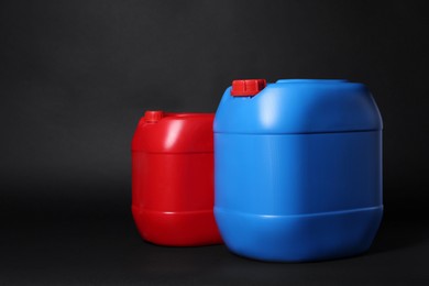 Two plastic canisters on black background, space for text