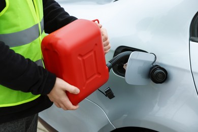 Photo of Man with canister refueling car outdoors, closeup