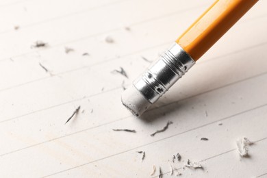 Photo of Using pencil with eraser on white sheet of paper, closeup