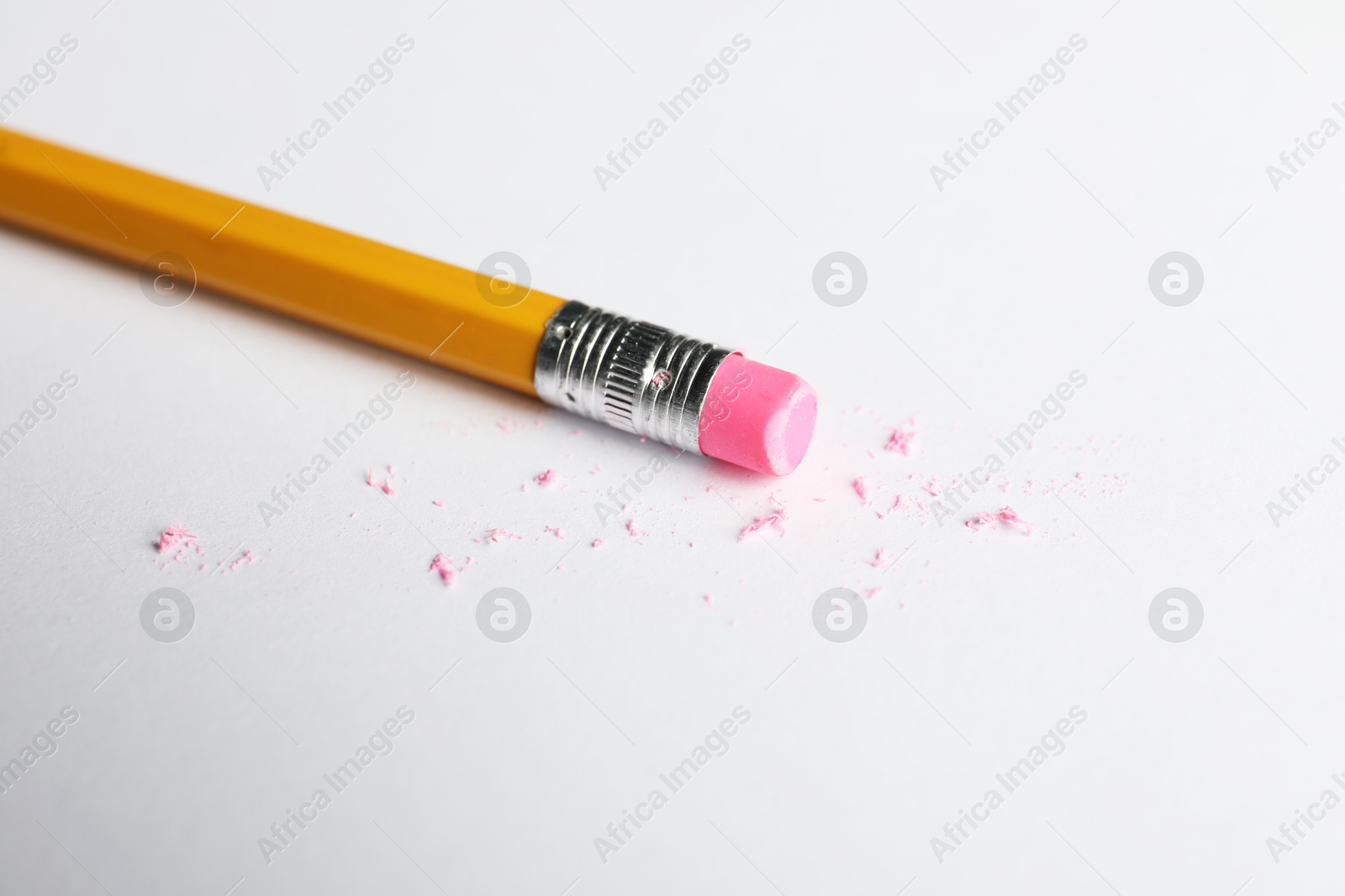 Pencil with eraser and scraps on white sheet of paper, closeup Photo of Pencil with eraser and scraps on white sheet of paper, closeup