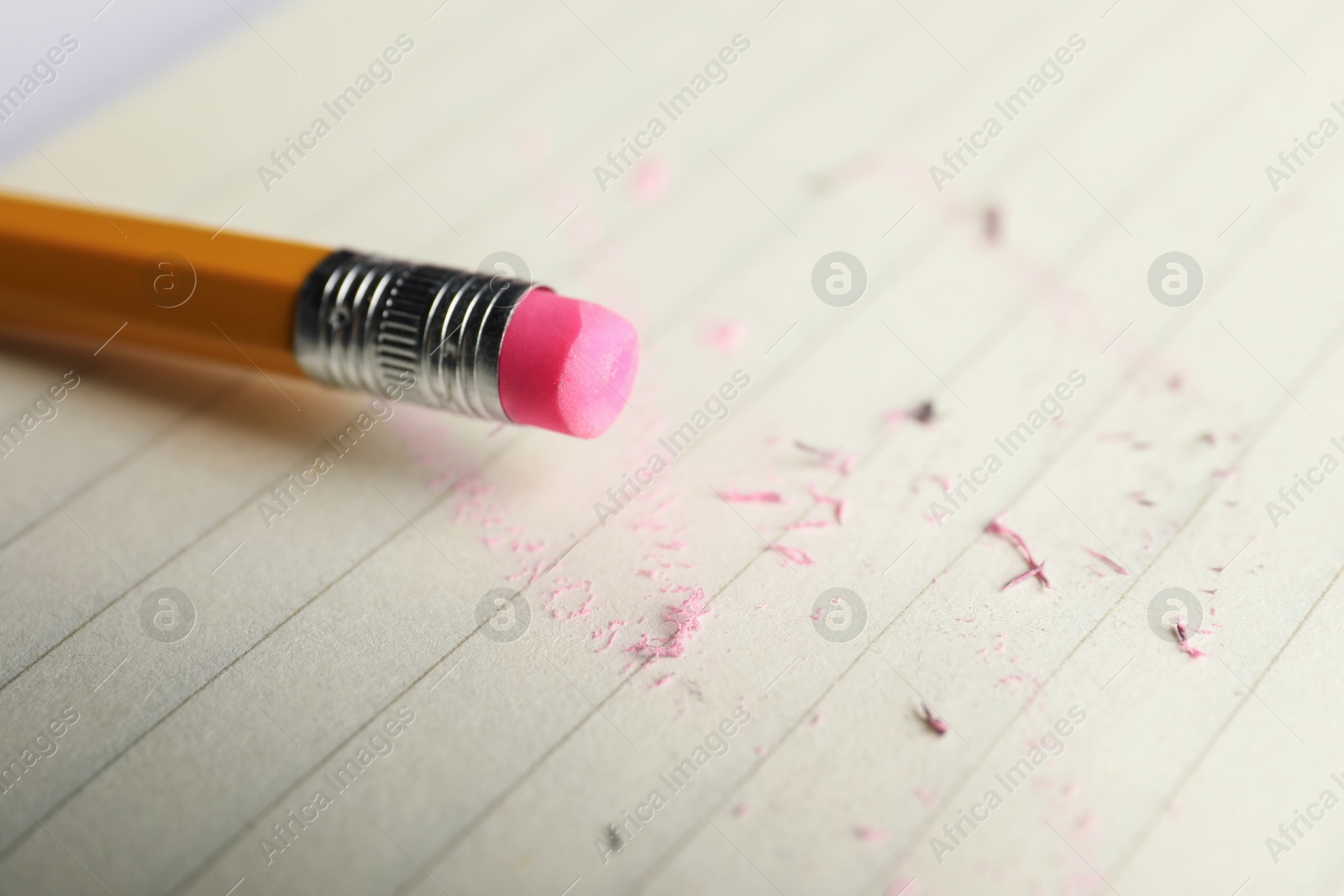 Pencil with eraser and scraps on sheet of paper, closeup Photo of Pencil with eraser and scraps on sheet of paper, closeup