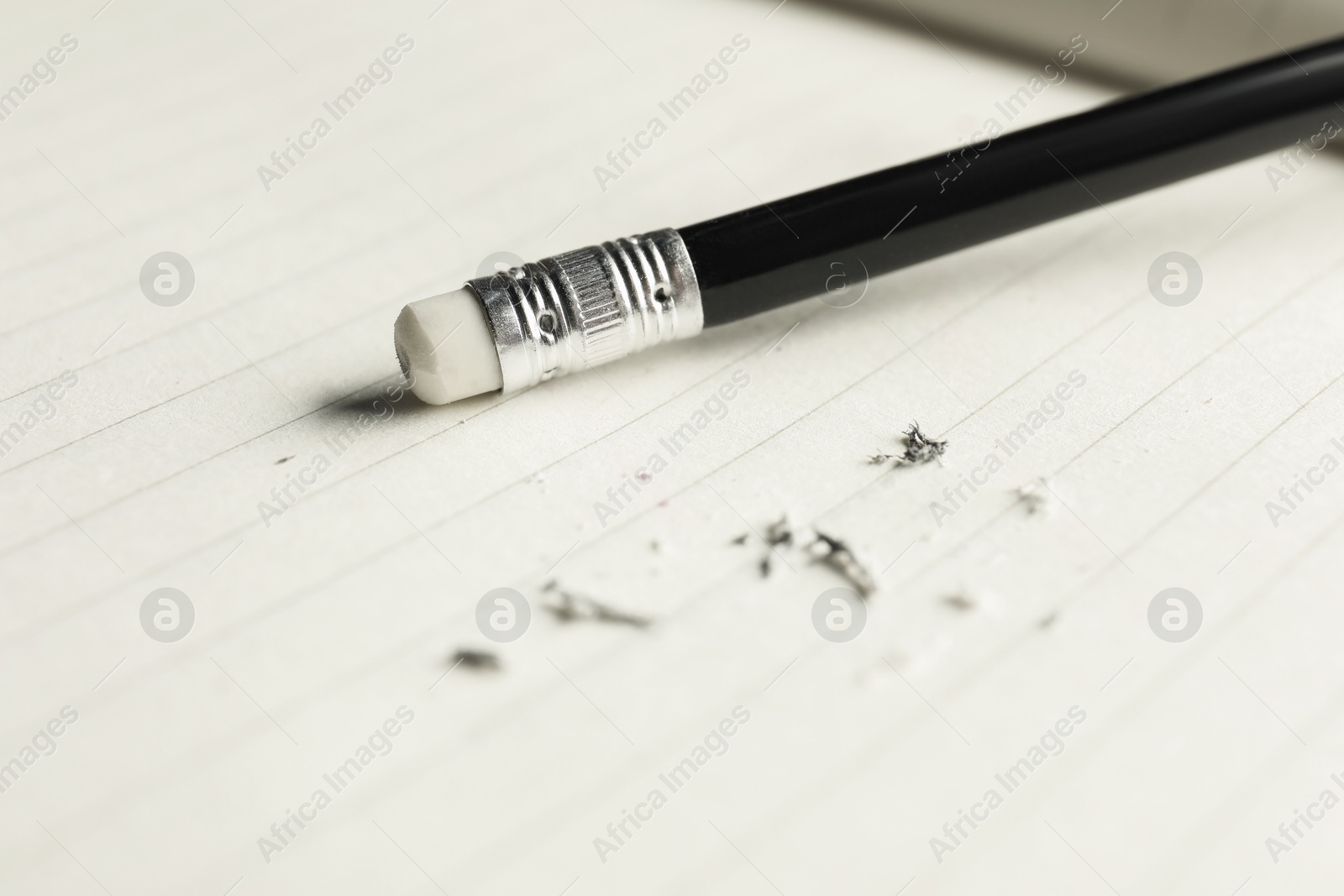 Pencil with eraser and scraps on sheet of paper, closeup Photo of Pencil with eraser and scraps on sheet of paper, closeup