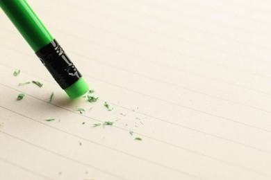 Photo of Using pencil with eraser on white sheet of paper, closeup