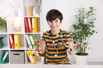 Photo of Boy with DNA structure model at desk indoors