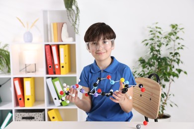 Photo of Boy with DNA structure model at desk indoors