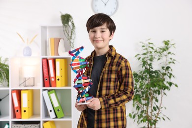 Smiling boy with DNA structure model indoors