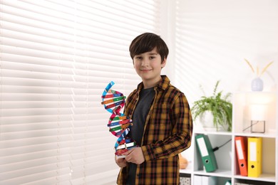 Photo of Smiling boy with DNA structure model indoors