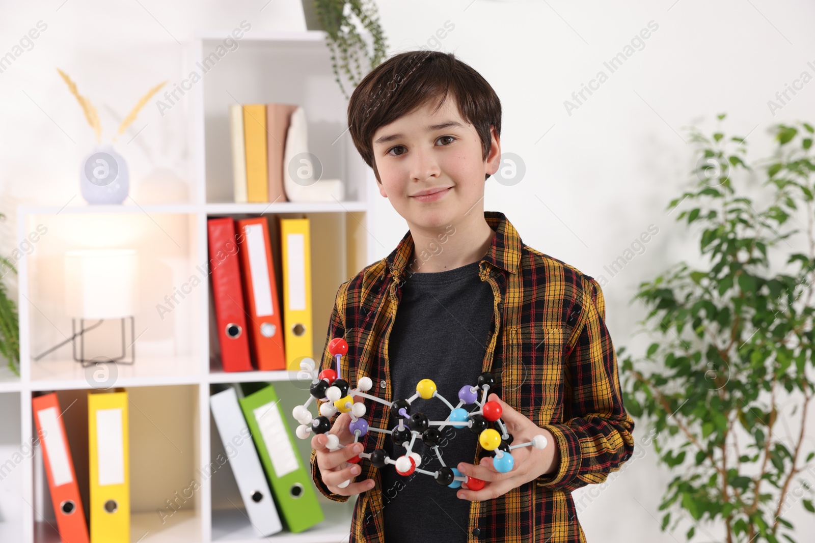 Photo of Smiling boy with DNA structure model indoors