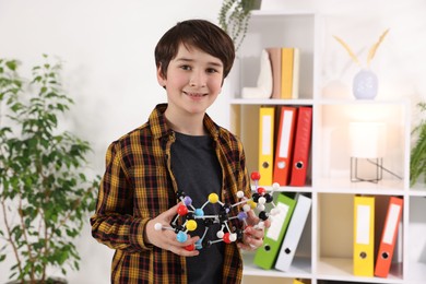 Photo of Smiling boy with DNA structure model indoors