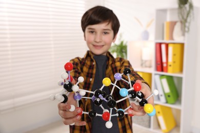 Photo of Boy with DNA structure model indoors, selective focus