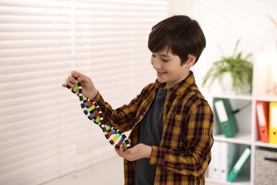 Smiling boy with DNA structure model indoors