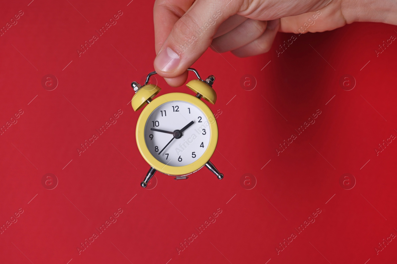 Photo of Man with alarm clock on red background, closeup. Space for text