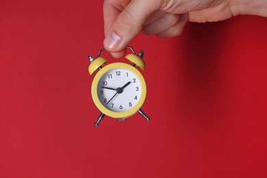 Man with alarm clock on red background, closeup. Space for text