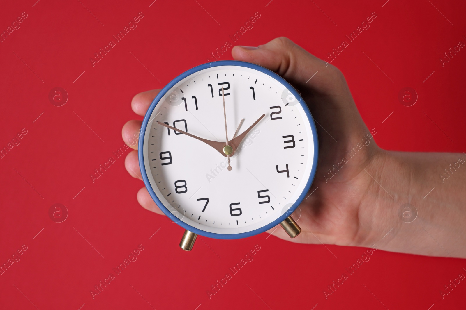 Photo of Man with alarm clock on red background, closeup