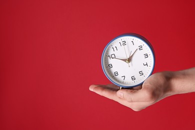 Man with alarm clock on red background, closeup. Space for text