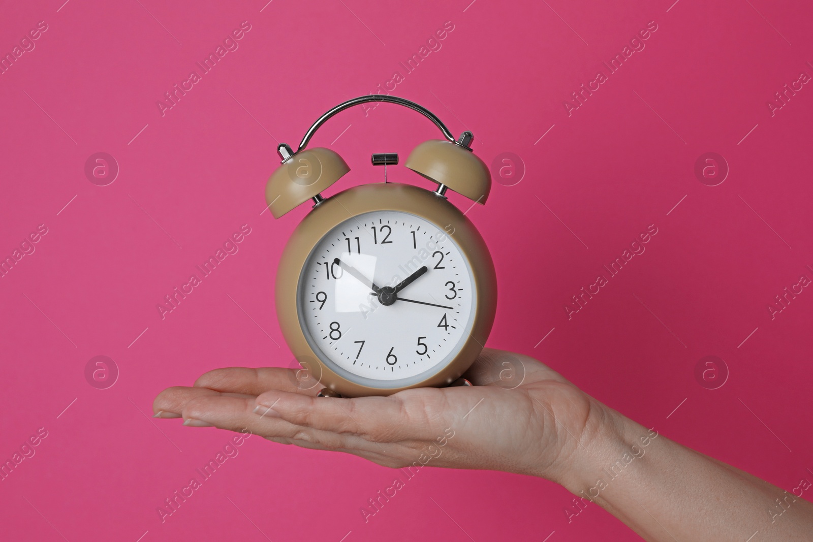 Photo of Woman with alarm clock on crimson background, closeup