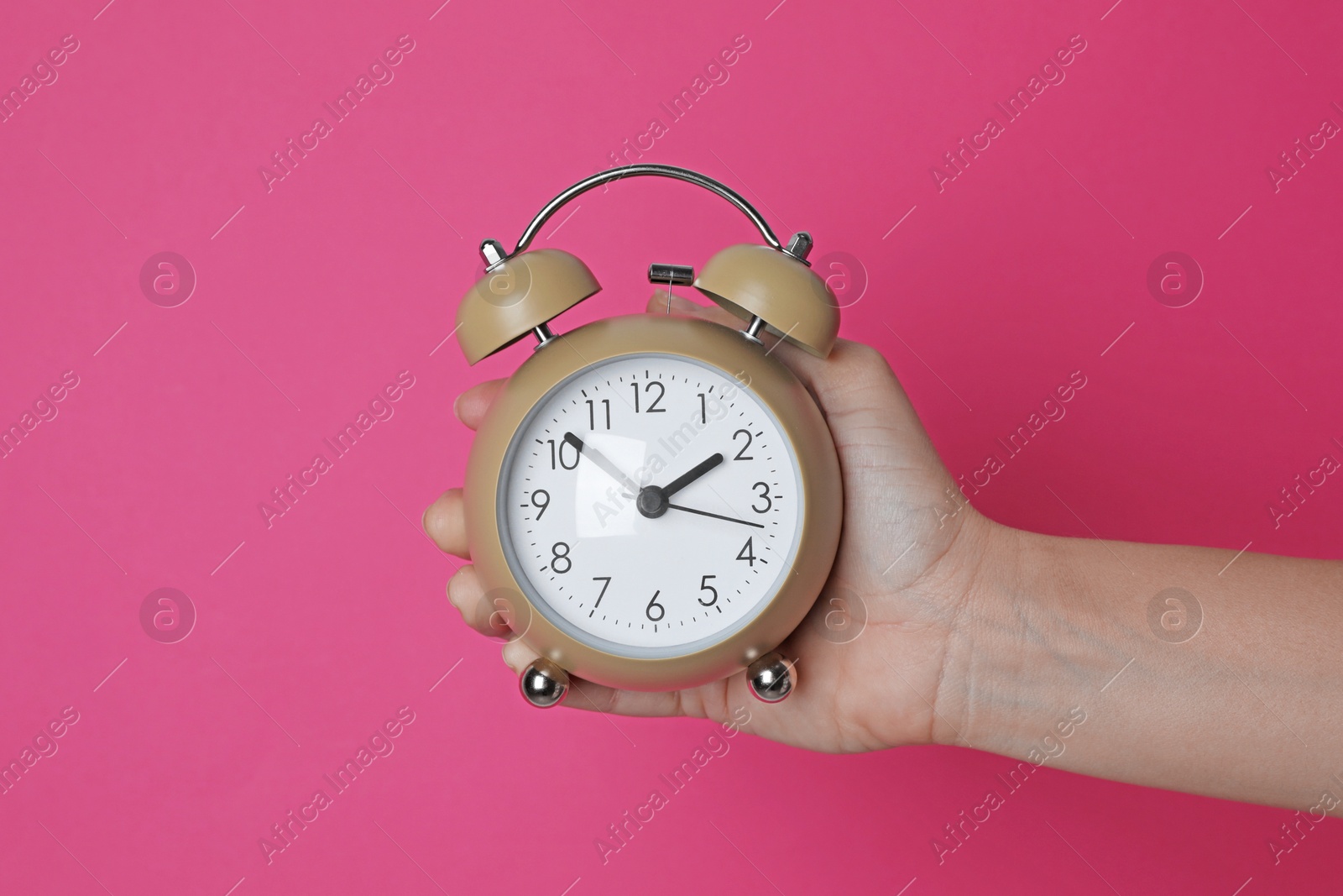 Photo of Woman with alarm clock on crimson background, closeup