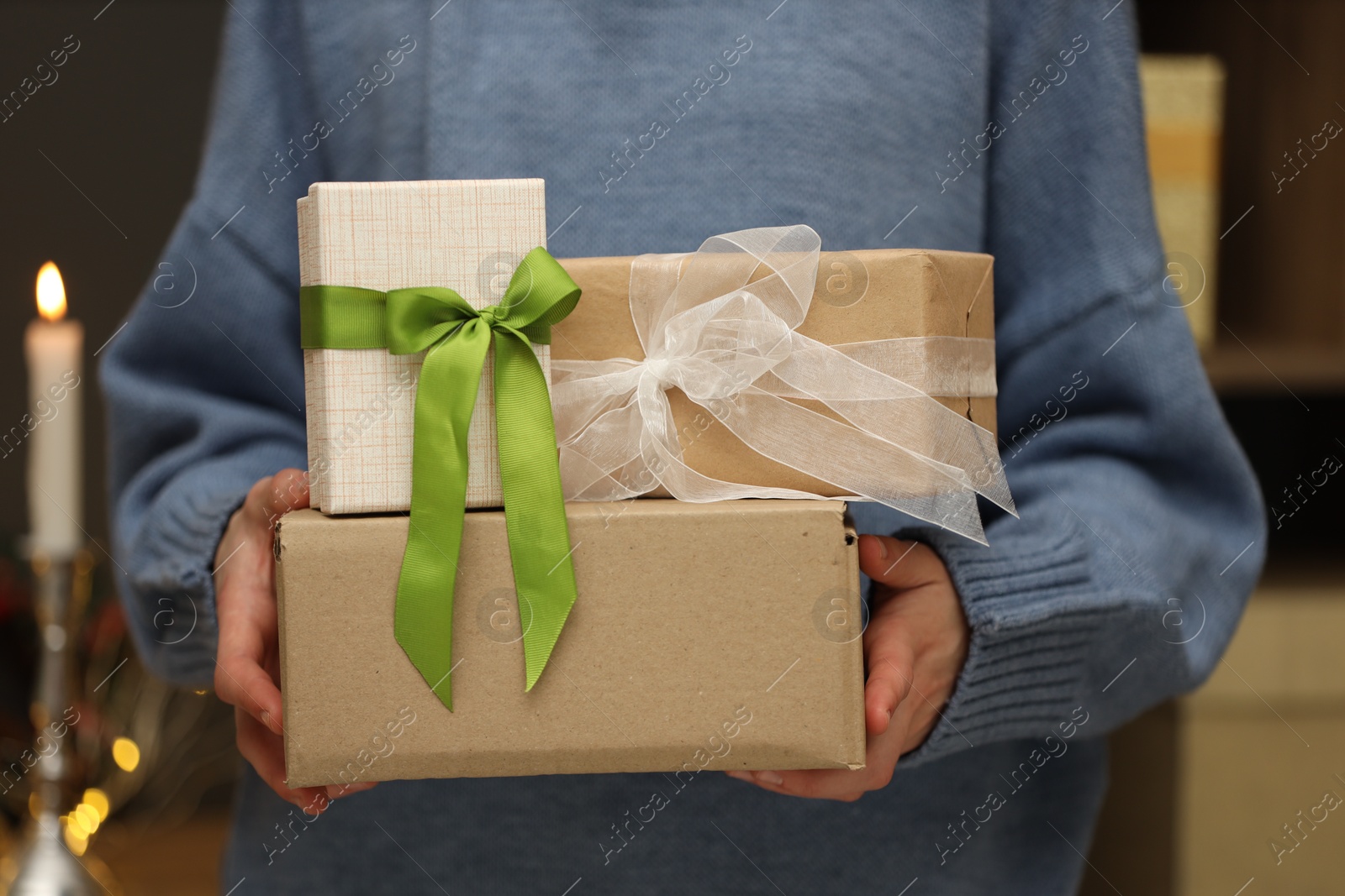 Woman with parcel and gift boxes indoors, closeup Photo of Woman with parcel and gift boxes indoors, closeup