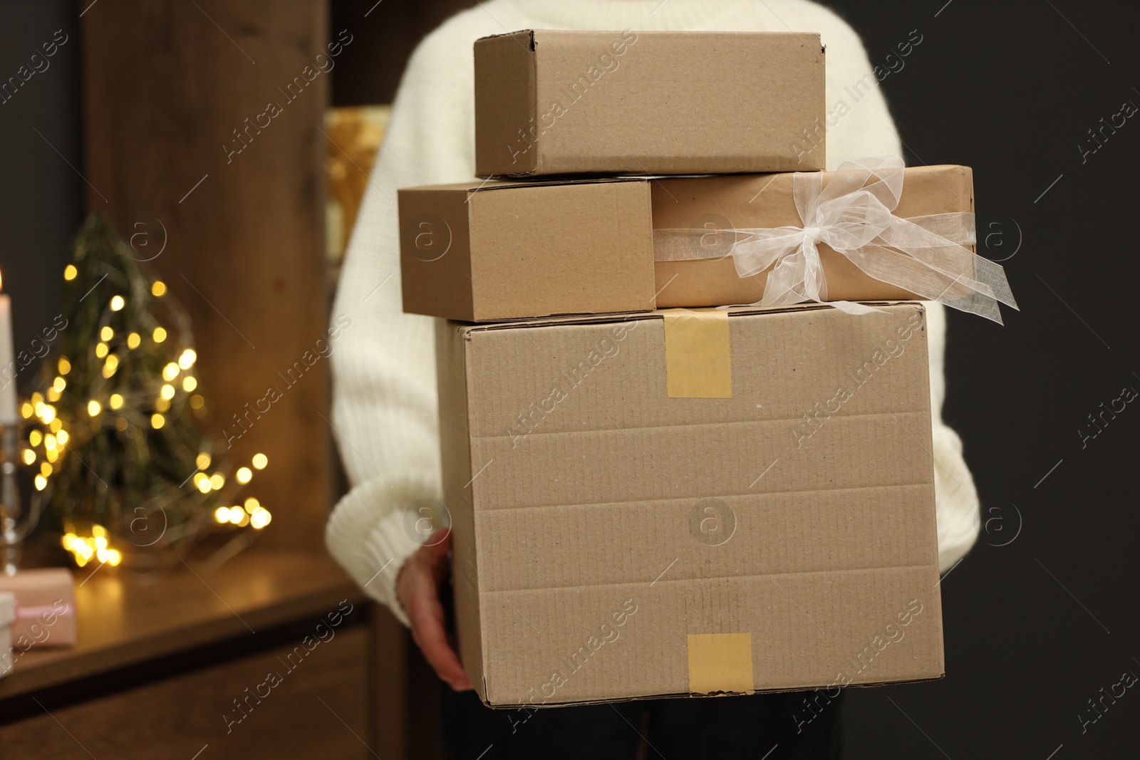 Woman with parcels and gift box indoors, closeup. Space for text Photo of Woman with parcels and gift box indoors, closeup. Space for text