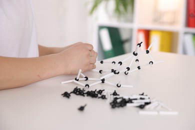 Photo of Boy making DNA structure model at desk indoors, closeup