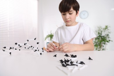 Photo of Boy making DNA structure model at desk indoors