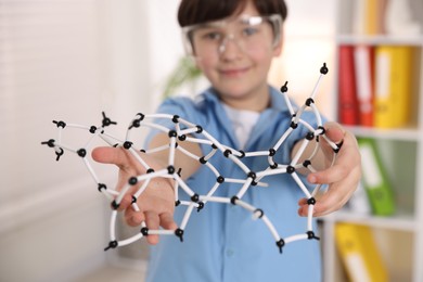 Photo of Boy with DNA structure model indoors, selective focus