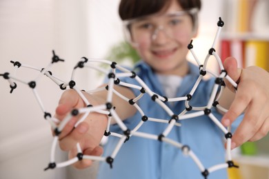 Photo of Boy with DNA structure model indoors, selective focus